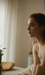 a girl with a bun sitting in front of a window