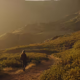 there is a male hiker that is heading down the hill