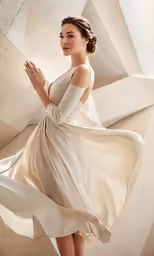 the woman is wearing a long sleeved wedding dress