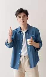 a boy is holding a paper cup and making a gesture