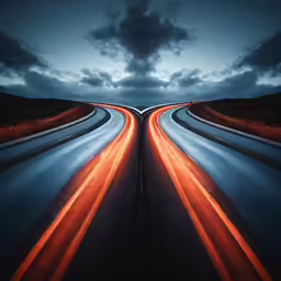 a long stretch of road with traffic lights streaking at night