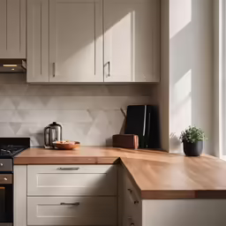 a wooden countertop sitting under a window next to cabinets