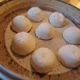 eight uncooked doughnuts sitting in a pan