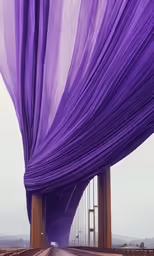 an interesting art installation of purple sheer fabric covering a bridge
