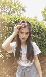 a young girl wearing gray shorts and a white shirt