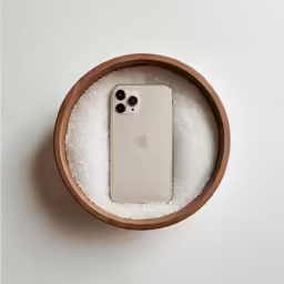 an iphone is sitting in a wooden container
