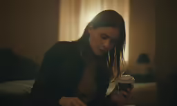 a girl holding her phone and looking at it
