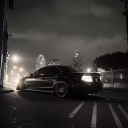 a black car driving down a street at night