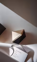two envelopes and an origami card in a box