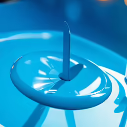 a close up of a blue vase with some water and a thing that looks like a spinner