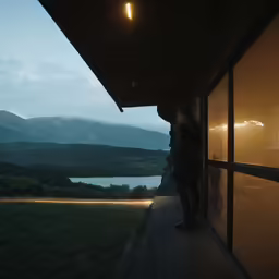 a person standing outside by a house looking out to the water