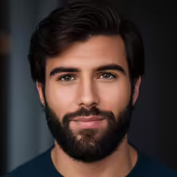 a man with dark hair and beard smiling for the camera