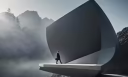 a person standing on the edge of a cliff overlooking mountains
