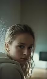 a woman looking into the camera with some water in her hair