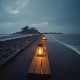 a light shines in between benches at the end of the ocean