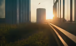 a train engine sitting next to a tall building in the sunset