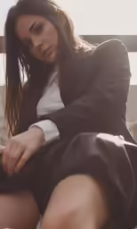 a woman in a skirt is sitting on a ledge