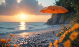 an umbrella sitting on the beach near flowers and rocks