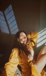 a woman in yellow dress laying on floor next to window