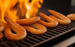 a barbecue grill with fire blazing in the background