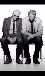 two men with ties sitting on a bench