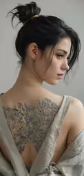 a very young woman with a tattoo on her back