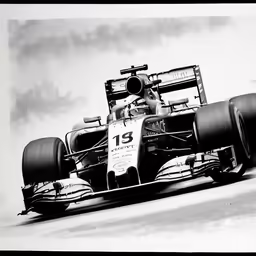 an old photo of a formula racing car driving
