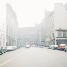 an empty city street with lots of cars in it