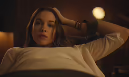 a woman looking out from behind a chair
