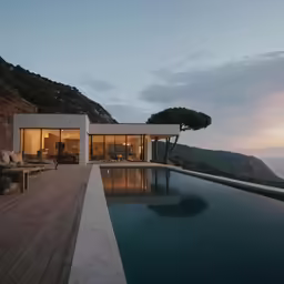 a modern villa by the sea with a wooden pool