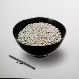 a plate of beans and two tongs in front of it