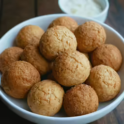 a white bowl filled with lots of tasty looking pastries