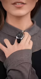 a person with a watch standing with their hand on his wrist