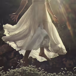 woman in white dress walking in grassy area under sunlight,the person is jumping in the air in this artistic photograph