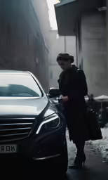 a woman standing by a car on the street