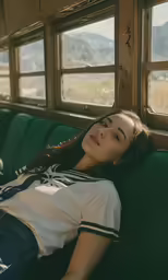 a woman laying on a green couch next to a window