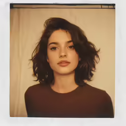 a girl with an open, slightly pulled up haircut and a brown top
