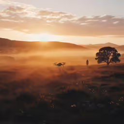 two men walking on top of a field at sunset