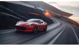 a red sports car driving down a road