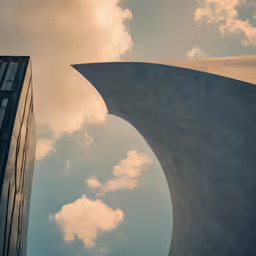 two tall buildings against the sky near clouds