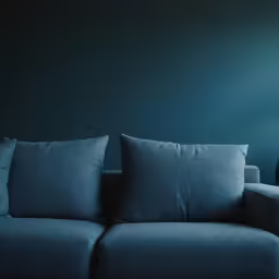 a sofa with blue fabric and matching pillow