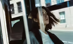 the woman is looking out of the bus window