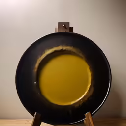 an uncooked pan of oil sitting on top of a wooden stand