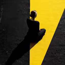 the woman is sitting on the yellow line