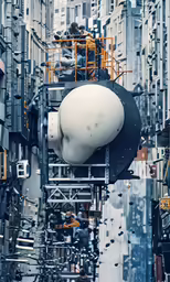 workers working on a piece of artwork with a white animal head