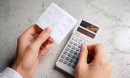 a man holds two parking permit slips from the calculator
