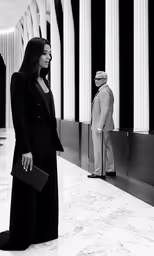 black and white photo of woman in suit and holding briefcase