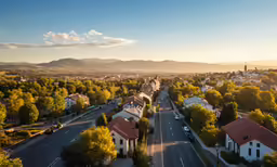 the sun sets on a small town in autumn