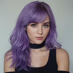 the model with long, purple hair looks into the camera