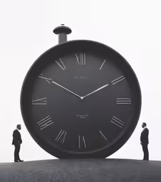 two people standing near a clock on top of a building